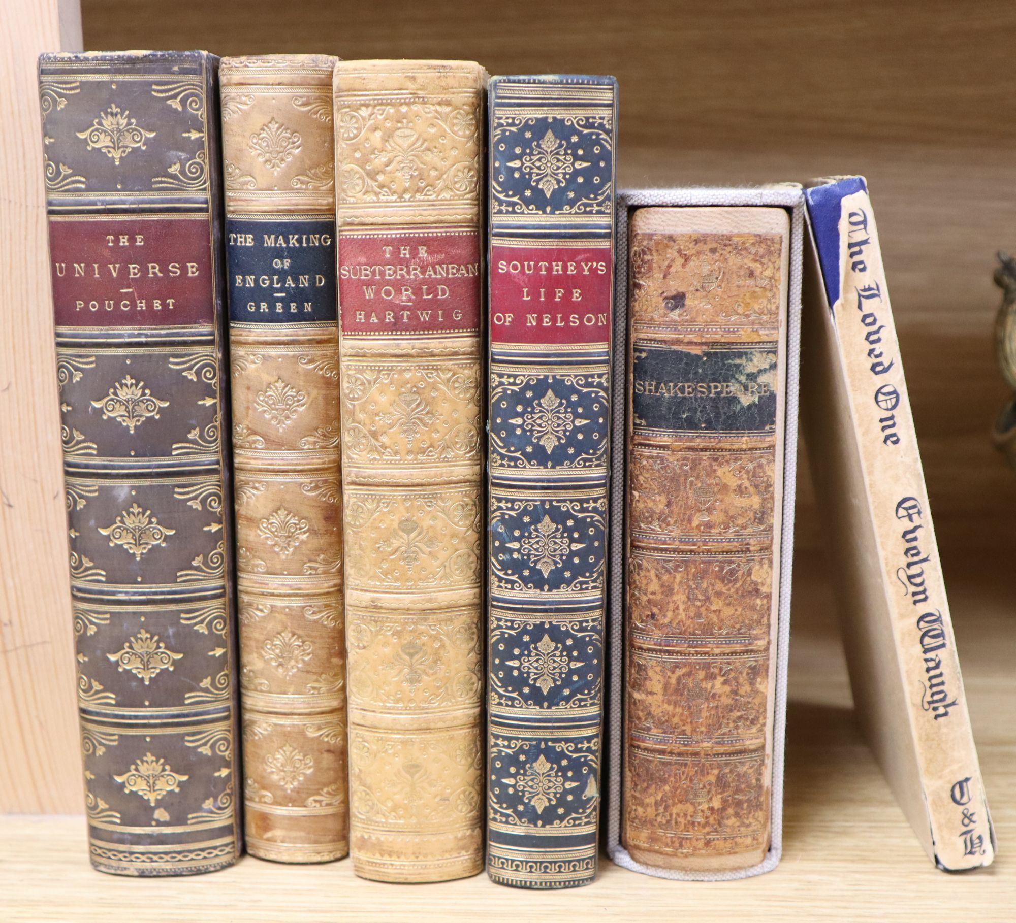 Five leather bound books and a Stuart Boyle novel The Loved One